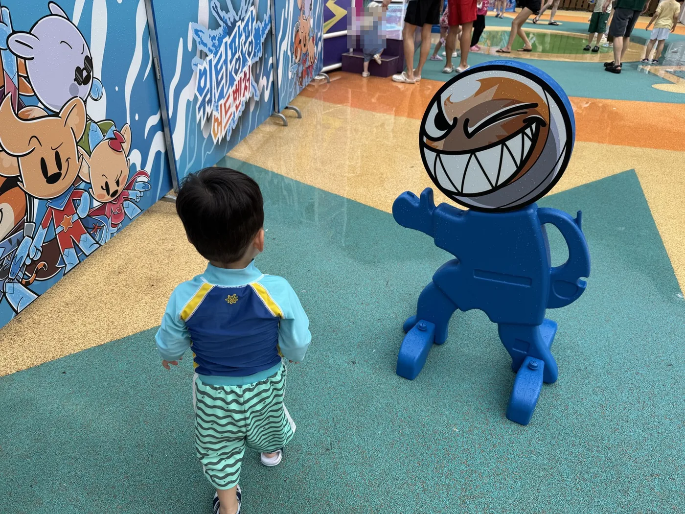 파란 밤밤맨 조형물 앞에 선 아이