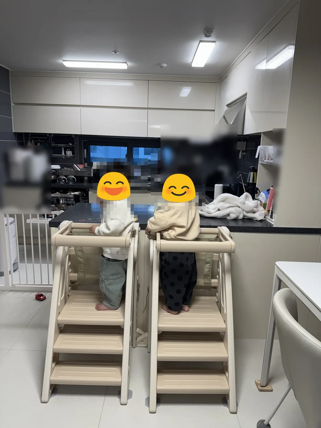 주방 아일랜드 식탁 옆에서 러닝타워에 선 쌍둥이